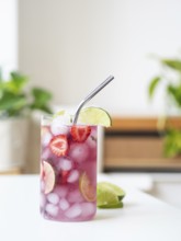 Glass of sparkling water with strawberries, lime, and ice, ready for drinking