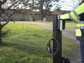 Technician installing a new ev charging station, promoting sustainable transportation solutions