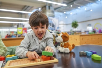 Young child experiencing joy and concentration while playing with colorful wooden building blocks