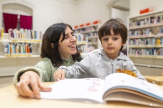 Mother and son sharing a joyful reading experience, with the woman smiling as they enjoy a book