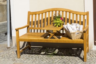 Inviting wooden bench with bouquet of flowers and display in front of a shop, Bautzen, Upper