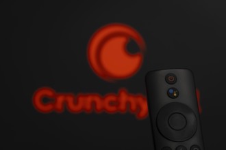 Dhaka, Bangladesh- 21 Jan 2026: Close-up of a smart TV remote control against a blurred Crunchyroll