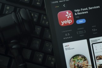 Dhaka, Bangladesh- 28 Oct 2025: An iPad displaying the Yelp app against a judge's gavel and dark