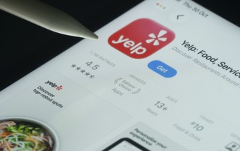 Dhaka, Bangladesh- 30 Oct 2025: Yelp app on a iPad screen with a pen pointing at the install option