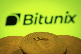 Dhaka, Bangladesh- 03 Sep 2025: Close-up of Bitcoin coins with the Bitunix logo visible on a screen