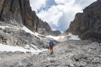 Hikers in a gap, Sentiero Brentari in front of rock faces, Brenta Mountains, Brenta-Adamello