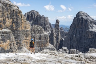 Hikers on the Sentiero Brentari hiking trail in front of cliffs, Brenta Mountains, Brenta-Adamello