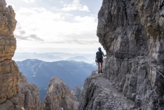 Climbers on a rock band, Bocchette Centrale band trail, via ferrata in the Brenta Mountains,