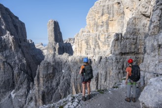 Mountaineers look at Campanile Alto pinnacle, Bocchette Centrale band trail, via ferrata in the
