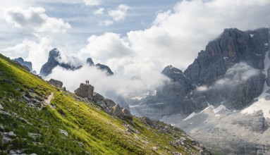 Alpine panorama, mountaineers on a large rock, fog and Torre Di Brentai and Cima Tosa, rocky