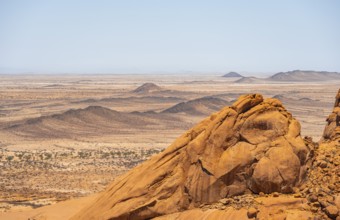 View of extensive desert landscape and distinctive rock formations on the horizon, Spitzkoppe,