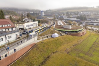 Panoramic view of a train with people in a hilly district during an event, opening of the Hermann