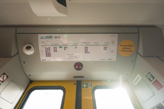 The interior of a train with a route plan and lighting on the ceiling, opening of the Hermann Hesse