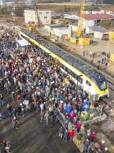 Assembly of people at a construction site event with a train, opening of the Hermann Hesse Railway,