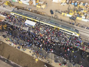 Dense crowd around a train on a construction site, taken from above, opening of the Hermann Hesse