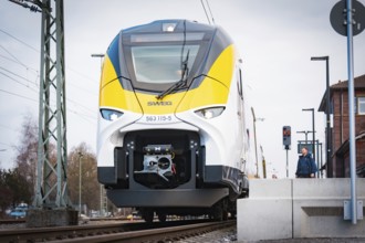Modern locomotive on tracks in front of a train station under cloudy sky, opening of the Hermann