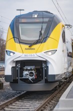 Close-up of the modern front of a white train with yellow elements, opening of the Hermann Hesse