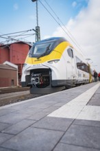 A modern train with a yellow front is on the platform, opening of the Hermann Hesse Railway, Calw,