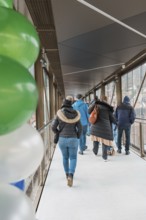 People on a covered bridge with colorful balloons, opening of the Hermann Hesse Railway, Calw,
