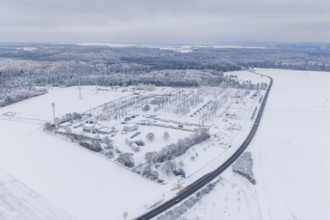 Aerial view of a snowy substation and a wide road in a winter landscape, substation, Jettingen,
