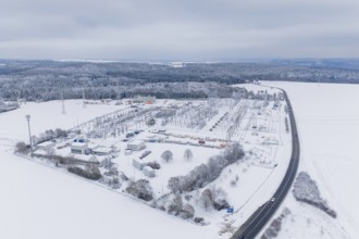 Aerial view of a snowy substation next to a country road in a winter landscape, substation,