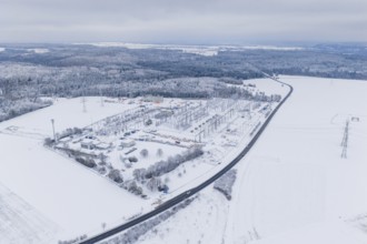Snowy substation and road in the midst of a winter landscape with thick forests, substation,