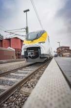 Train in the distance on the tracks heading to the platform, battery electric train Siemens Micro