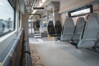 Modern, empty interior view of a train with grey and yellow seats, Siemens Micro Plus B battery