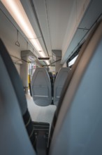 View from the aisle of a modern train with grey seats and lights, Siemens Micro Plus B battery