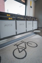 Detailed view of a bicycle parking space in a train compartment with folding seats, battery