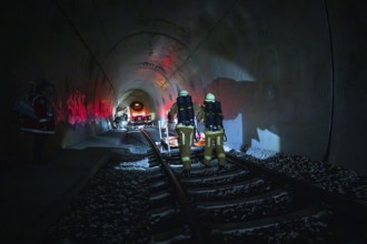 Firefighters walk through a tunnel in a dark, glowing atmosphere, fire drill at the Hermann-Hesse