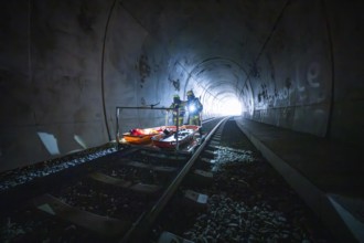 Firefighters on an emergency vehicle in a dark tunnel at the end during daylight, fire drill at the