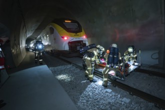 Firefighters work in a tunnel next to a train on a rescue operation, fire drill on the