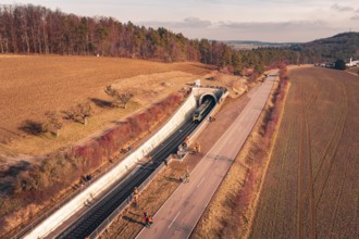 Aerial view of a train near a railway tunnel with emergency services and surrounding landscape,
