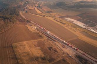 Fire trucks on a country road with a view of surrounding fields and village at dusk, fire drill on