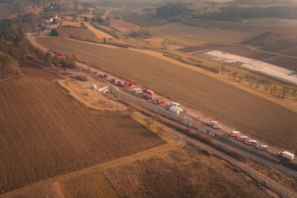Aerial view of fire engines on a country road with tunnel and surrounding fields, fire drill on the