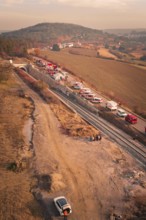 Aerial view of rural scenery with vehicles, tunnels and hills in the background, fire drill on the