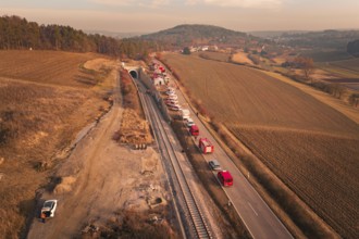 Aerial view with emergency vehicles next to a tunnel and fields in the background, fire drill at