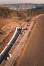 Aerial view of a tunnel with emergency vehicles and barriers along the road, fire drill on the