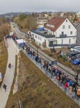 Numerous people lining up along the tracks in a village, opening of the Hermann Hesse Railway,