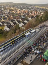 A train stops in a village, many people wait at the platform, opening of the Hermann Hesse Railway,
