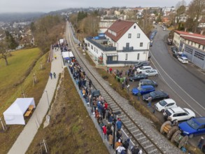 A train station with many people, located in an urban area with roads, opening of the Hermann Hesse