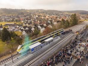 Train arrival at a busy train station with crowds and city views, opening of the Hermann Hesse