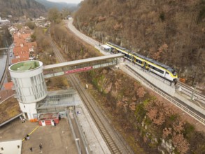 Landscape view of a railway station with bridge, hills and city in the background, opening of the