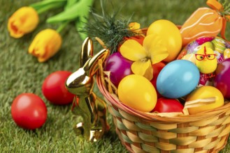 A basket with colorful eggs, flowers and Easter decoration in a meadow