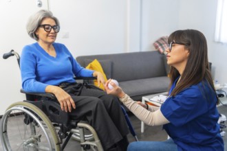 Caregiver working with a senior woman in a wheelchair, providing assistance and support during