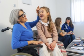 Granddaughter laughing while visiting her grandmother in a wheelchair, sharing a heartwarming