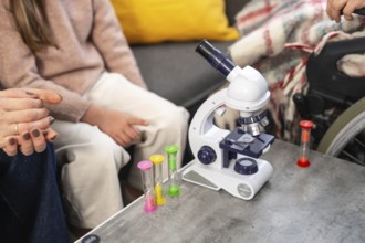 Granddaughter and family explore science together with a microscope and sand timers during a warm