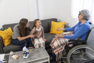 Three generations of family members warmly interacting, an elderly woman in a wheelchair engaging