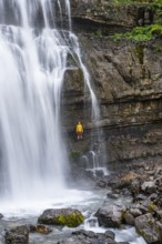Adventure, Little hiker under large Cascata di Mezzo waterfall, long exposure, Vallesinella,